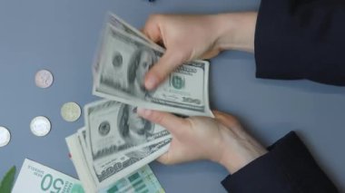 Dolar sayan bir kadın. Kadın eli kapalı, nakit para sayar. Kadın çalışan maaşı sayar. Nakit para ödemesi. Finansal iş kavramı. Dikey video