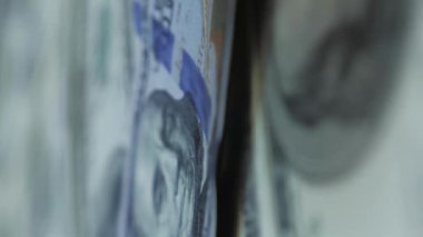 Dolar üzerinden nakit para düşüyor. Düşen dolar banknotları. 100 dolarlık banknotlara karşı nakit para geçmişi. Dikey video