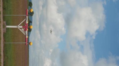 Bulutlu mavi gökyüzüne iniş yapan yolcu uçağı. Dikey video. İki motorlu jet uçağı gökyüzüne doğru uçuyor.