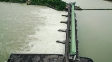 Hidroelektrik su barajının açık kapısından büyük bir şelale düşüyor. Sel üstüne su ile taşan nehir. Doğal afetler