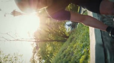 Güçlü bisikletçi dağa tırmanıyor, yakından takip ediyor. Kaslı bacaklı erkek sporcu bisikletle tepeye tırmanıyor. Bisiklet konsepti. Dikey video
