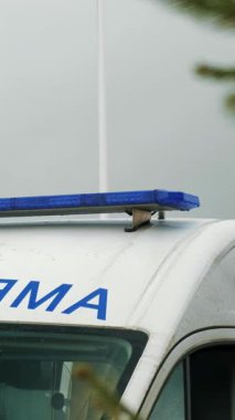 Ambulansı kapatın. Mavi ışıklar yanıp sönüyor. Acil servis ambulansının yanıp sönen ışıkları. Dikey video