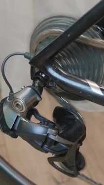 Mechanic checking switches and circuit work, bike wheel and chain rotation, close up. Bicycle mechanic working at bicycle repair shop fixing bicycle and spinning back wheel. Vertical video