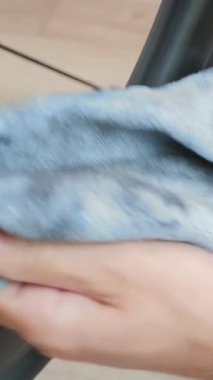 Bike maintenance. Bicycle mechanic cleaning bike chain with microfiber cloth, close up of chain. Male hands clean bicycle chain with cloth. Bicycle workshop. Vertical video