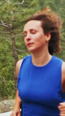 Active woman running outdoors in mountains. Determined confident female running and achieving her sports goals. Athletic woman in sport clothes jogging. Fitness workout. Vertical video