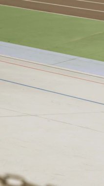 Cyclists on fixed gear bikes are cycling at velodrome. Vertical video. Professional cyclists are riding fast at cycling track. Cycling concept