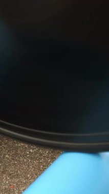 Rear wheel of track bicycle rotating. Bicycle wheel spinning. Man working out on exercise bike on cycling track. Vertical video