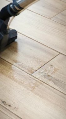 Elektrikli süpürgeyle yerleri yıkıyorum. Elektrikli süpürgeyle temizlik yapan kadın. Ev işi temizlik konsepti. Dikey video