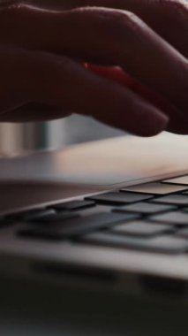 Dizüstü bilgisayar kullanarak ve klavyede yazı yazarak kadın parmaklarını kapat. Kadın elleri not defteri kullanıyor, klavyeye mesaj yazıyor. İş konsepti. Dikey video