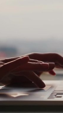 Ofisteki dizüstü bilgisayarın klavyesinde büyük pencereye karşı parmaklarını kapat. Dikey video