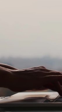 Ofisteki dizüstü bilgisayarın klavyesinde yazarken parmaklarını kapat. İş adamı ya da iş kadını elleri klavyede daktilo kullanıyor. Dikey video