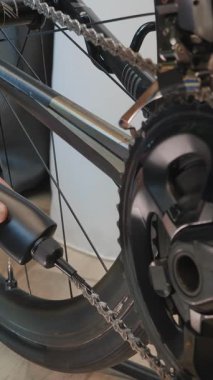 Tamirci bisiklet zincirini kayganlaştırıcı ile kayganlaştırıyor. Beyaz kayganlaştırıcılı bisiklet zinciri ve şanzıman temizleme ve yağlama. Dikey video