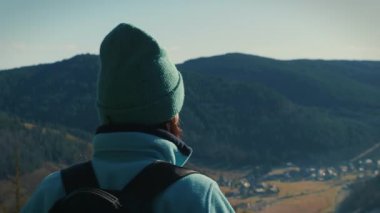 Female tourist with backpack hiking and standing on mountain top, exploring picturesque mountain nature. Woman hiker enjoying mountain landscape in South Germany. Travel and active lifestyle