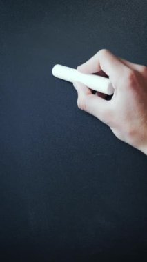 Hand writing discounts 50 percent on chalkboard. Male hand writes with chalk on blackboard 50% promotion discount offer. Vertical video