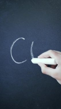 Hand writes Covid-19 and crosses it out with chalk on blackboard, close up. Vertical video