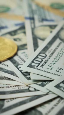 Golden bitcoins falling on dollar bill background. Blockchain cryptocurrency technology. Virtual money. Vertical video