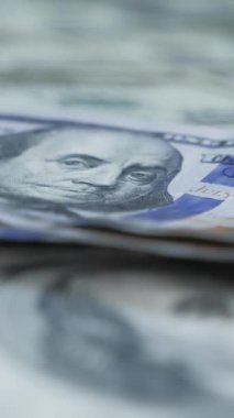 One hundred american dollar banknotes falling on cash money background. Falling dollar paper bills. Vertical video