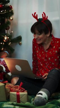 Smiling happy woman is celebrating Christmas and New Year festive holidays alone, making webcam video call conference with family, talking and laughing. Happy New Year 2026. Vertical video