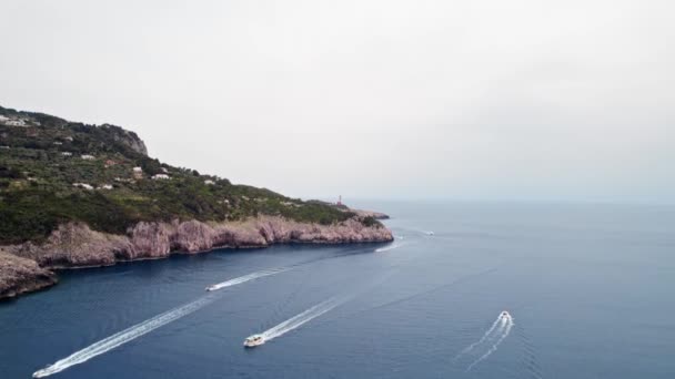 イタリア活気に満ちたカプリボートヨットクリフ展望台灯台上昇傾斜ドローン空中 — ストック動画