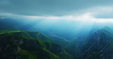Dağlarda saklı küçük bir köy Bulutların arasından parlayan güneş ışınları Hava Aracı