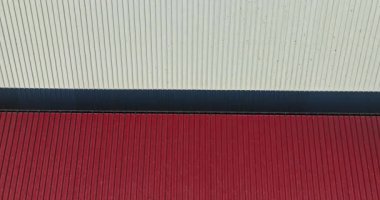 Kuş göçü, güneşli bir günde Kırmızı ve Beyaz Çatı 'nın üzerinde uçuyor.