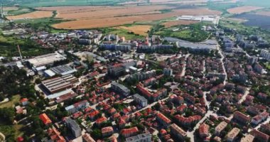 Eski apartman binaları ve insansız hava araçları olan küçük bir kasabanın dışındaki büyük fabrikalar.
