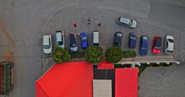 Bir restoranın önüne kötü park edilmiş arabalar. Gün batımında hava aracı hala uçakla ateş ediyor.
