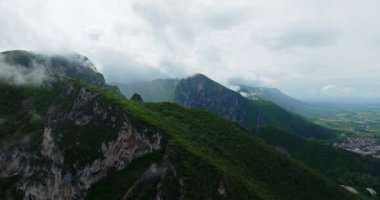 Tropikal dağ sırasının üzerinde oluşan yağmur bulutları küçük konforlu yüksek irtifa köyüne tepeden bakıyor.