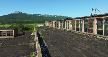 Deponun çatısında kırılan cam paslı döküntüler canlı kanyon manzarasına bakıyor.