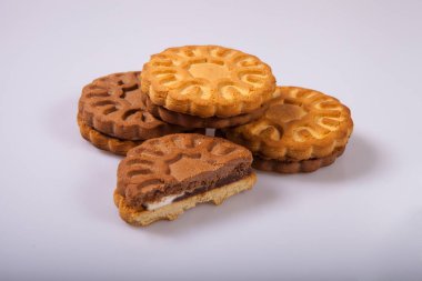 Round cookies with filling on light background in studio. Several pieces of round cookies isolated on light background in studio