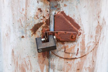Metal kapıdaki paslı asma kilit.