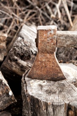 Eski paslı balta dışarıda yakacak odun arka planında..
