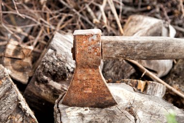 Eski paslı balta dışarıda yakacak odun arka planında..