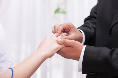Damat gelinin parmağına altın bir alyans takar. Geleneksel alyans takası..