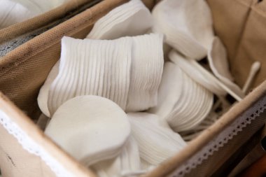 Makyaj malzemelerini çıkarmak için pamuk pedler yakın plan çekilen bir sepette.