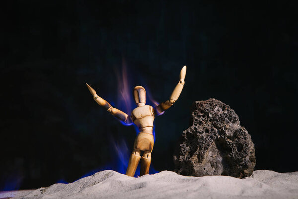 Wooden model of a man engulfed in flames. Burning wooden human figurine. Burnout concept.
