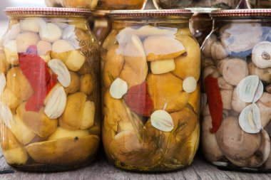 Metal kapaklı cam kavanozlarda mantar turşusu. Konserve mantar.