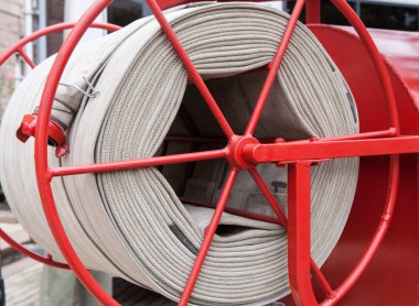 Eski bir itfaiye aracının makarasında yangın hortumu yarası. Eski bir itfaiye aracında yangın hortumu..