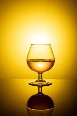bir yudum konyak masada zarif tipik konyak cam yansıması sıcak bir atmosfer ile.