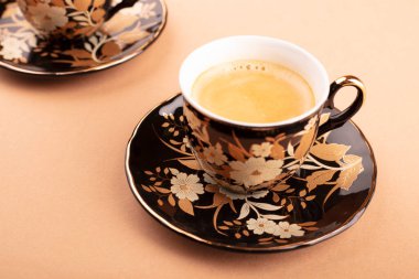 Kahve dükkanının ahşap masasında bir fincan Latte ve kahve çekirdeği..