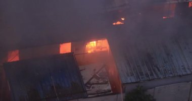 İtfaiyeciler yanan binayı söndürüyor.