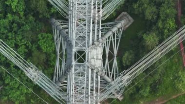 high-voltage pole in the green forest. drone view.