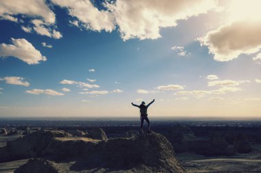 Başarılı bayan sırt çantalı kendini çöl tepesinde özgür hisseder.