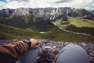 Yüksek rakımlı dağın tepesindeki yürüyüşçü manzaranın tadını çıkar.