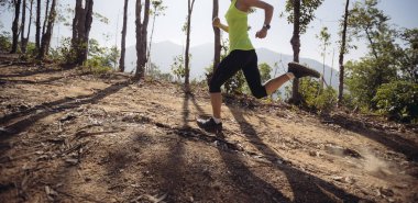 Woman trail runner running at tropical forest mountain peak