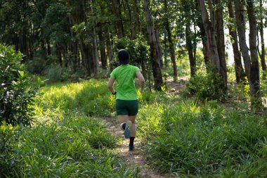 Tropikal orman dağlarında koşan bir kadın izci. 