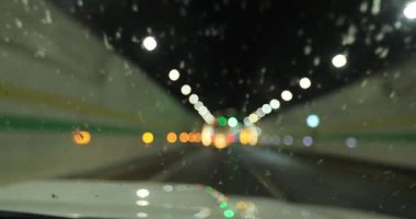 Yeraltı tünelinde ışıklarla giden araba.