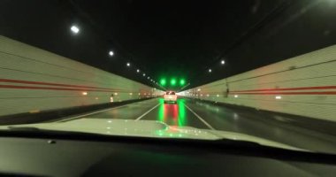 Yeraltı tünelinde ışıklarla giden araba.