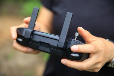 People remote control a flying drone in summer forest