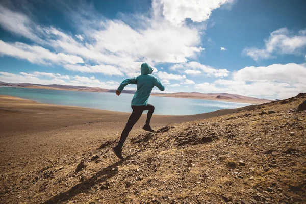 stock image Woman trail runner cross country running in lakeside mountains